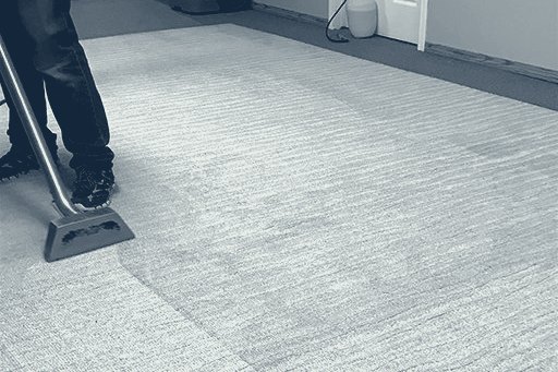 Technician cleaning a carpet with a wand